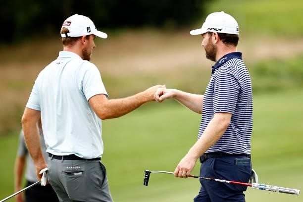 Russell Henley of the United States fist bumps Branden Grace of South Africa after Grace make a birdie putt on the seventh green during the final...