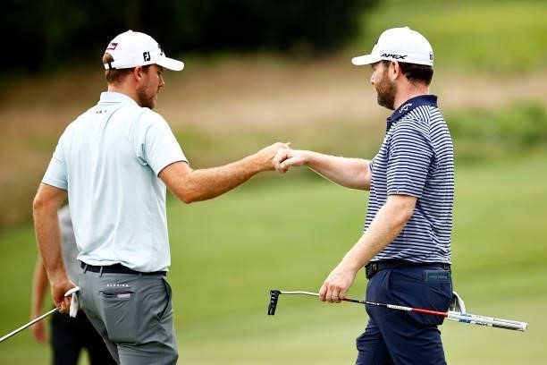 Russell Henley of the United States fist bumps Branden Grace of South Africa after Grace make a birdie putt on the seventh green during the final...