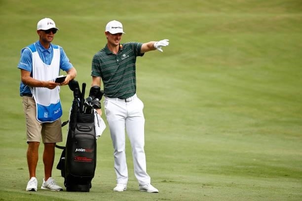 Justin Rose of England talks with caddie David Clark on the 11th fairway during the final round of the Wyndham Championship at Sedgefield Country...