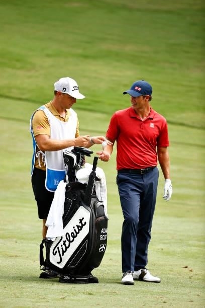 Adam Scott of Australia talks with caddie John Limanti on the 11th fairway during the final round of the Wyndham Championship at Sedgefield Country...