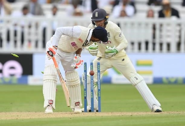 Ravindra Jadeja of India is bowled as Jos Buttler looks on during the fourth day of the 2nd LV= Test match between England and India at Lord's...