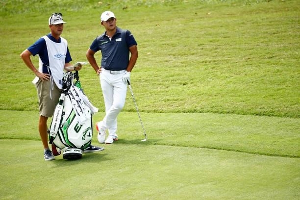 Si Woo Kim of South Korea waits with caddie Brian Vranes on the 17th hole during the final round of the Wyndham Championship at Sedgefield Country...