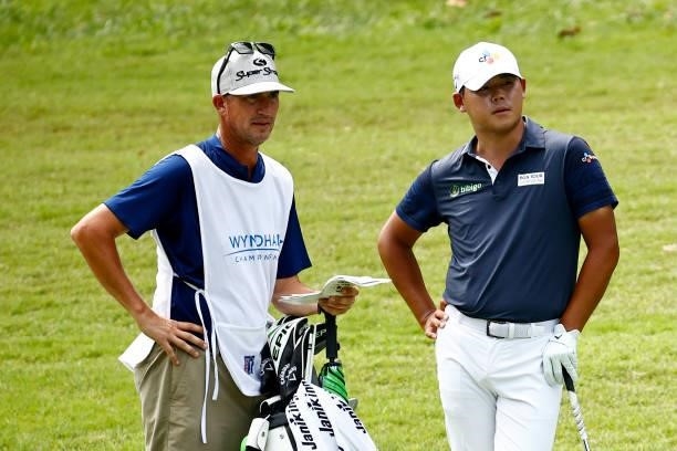 Si Woo Kim of South Korea waits with caddie Brian Vranes on the 17th hole during the final round of the Wyndham Championship at Sedgefield Country...