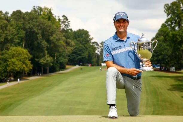 Kevin Kisner of the United States celebrates with the trophy after winning a 6-way sudden-death playoff during the final round of the Wyndham...