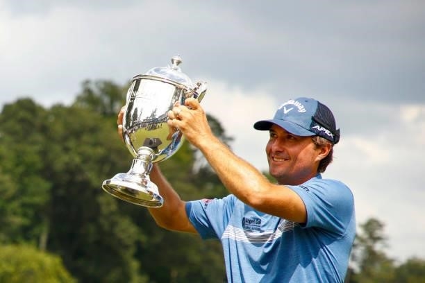 Kevin Kisner of the United States celebrates with the trophy after winning a 6-way sudden-death playoff during the final round of the Wyndham...