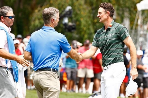 Kevin Streelman of the United States and Justin Rose of England shake hands on the 18th green during the final round of the Wyndham Championship at...