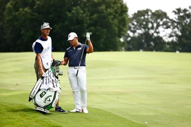 Si Woo Kim of South Korea waits with his caddie Brian Vranes before hitting an approach shot on the 18th hole during the final round of the Wyndham...