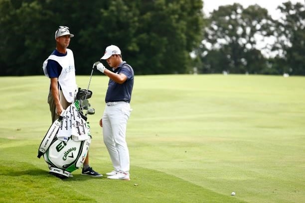 Si Woo Kim of South Korea waits with his caddie Brian Vranes before hitting an approach shot on the 18th hole during the final round of the Wyndham...