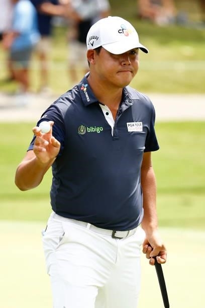Si Woo Kim of South Korea waves after making a birdie on the 17th green during the final round of the Wyndham Championship at Sedgefield Country Club...