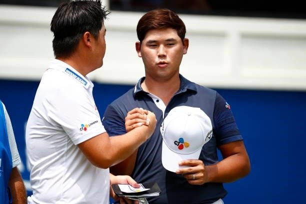 Sungjae Im of Korea and Si Woo Kim of South Korea shake hands on the 18th green during the final round of the Wyndham Championship at Sedgefield...