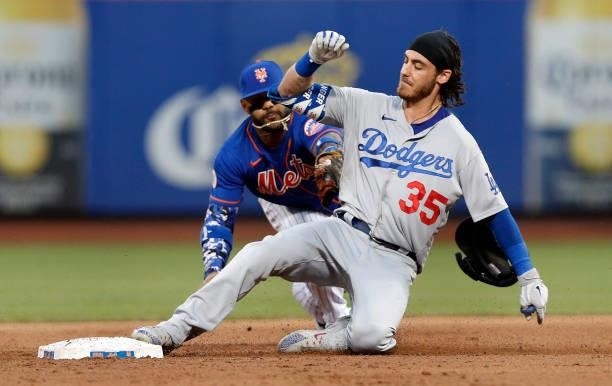 Cody Bellinger of the Los Angeles Dodgers slides into second base ahead of the tag of Jonathan Villar of the New York Mets for a double in the second...