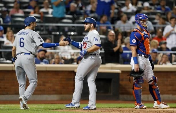 Max Muncy of the Los Angeles Dodgers celebrates his two-run home run with teammate Trea Turner as James McCann of the New York Mets looks on in the...