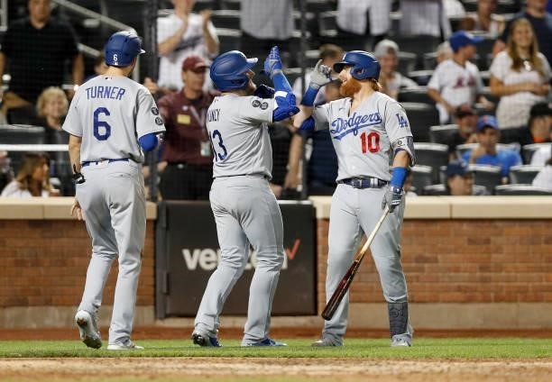 Max Muncy of the Los Angeles Dodgers celebrates his sixth inning two run home run against the New York Mets with teammates Justin Turner and Trea...