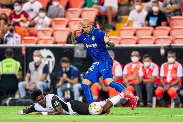 Thierry Correia of Valencia CF competes for the ball with Sandro Ramirez of Getafe CF during the La Liga Santander match between Valencia CF and...