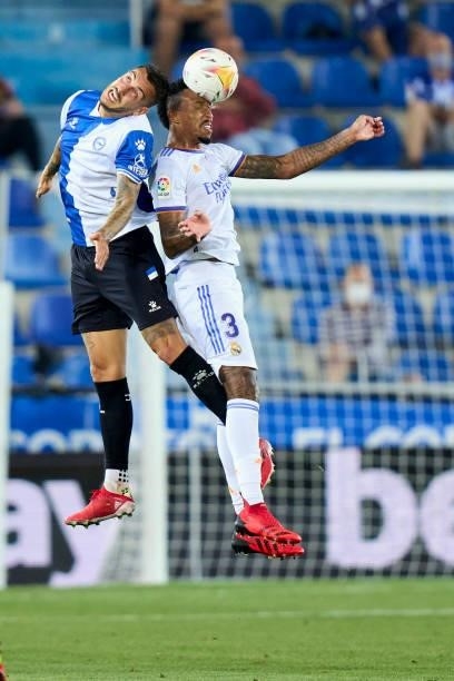 Joselu of Deportivo Alaves battle for the ball with Eder Militao of Real Madrid CF during the La Liga Santader match between Deportivo Alaves and...