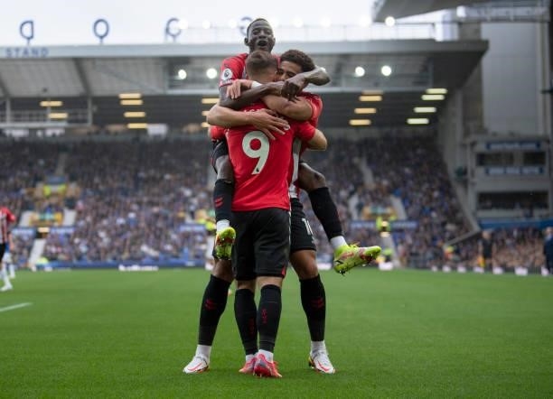 Moussa Djenepo of Southampton celebrates with golscorer Adam Armstrong and team mate Che Adams during the Premier League match between Everton and...