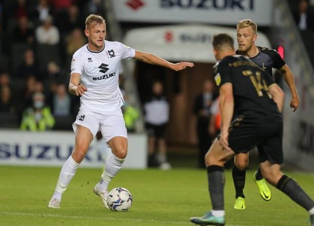 Harry Darling of Milton Keynes Dons moves forward with the ball watched by Jayden Stockley of Charlton Athletic during the Sky Bet League One match...
