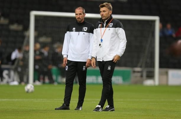 Milton Keynes Dons assistant first team coach David Wright and assistant head coach Chris Hogg look on during pre match warm up prior to the Sky Bet...