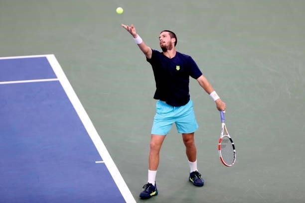 Cameron Norrie of Great Britain serves to John Isner during the Western & Southern Open at Lindner Family Tennis Center on August 17, 2021 in Mason,...