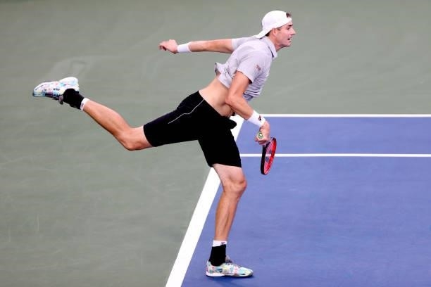 John Isner serves to Cameron Norrie of Great Britain during the Western & Southern Open at Lindner Family Tennis Center on August 17, 2021 in Mason,...