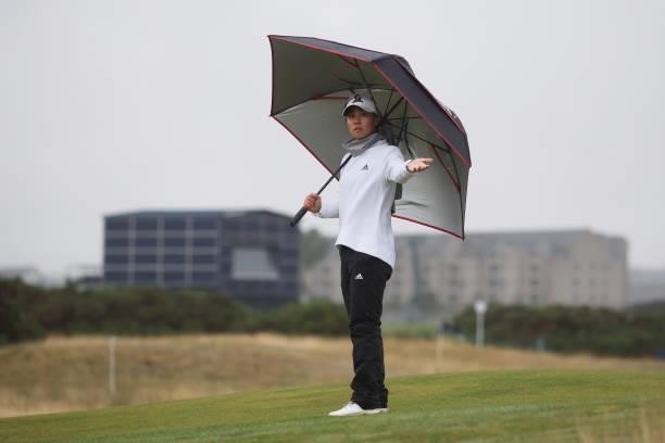 Danielle Kang of The United States checks for rain as she holds and umbrella during Day One of the AIG Women's Open at Carnoustie Golf Links on...