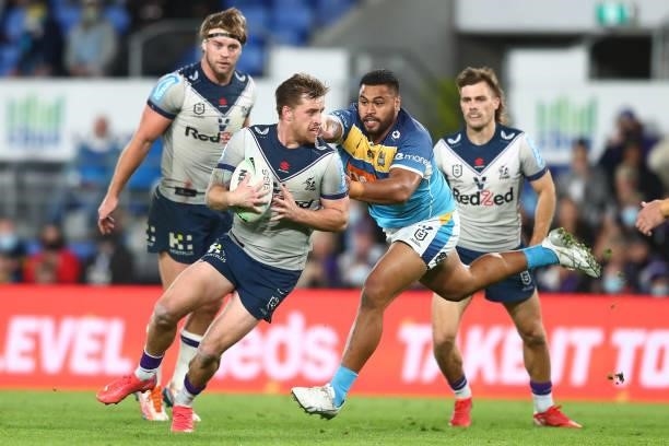 Cameron Munster of the Storm is tackled during the round 23 NRL match between the Gold Coast Titans and the Melbourne Storm at Cbus Super Stadium, on...