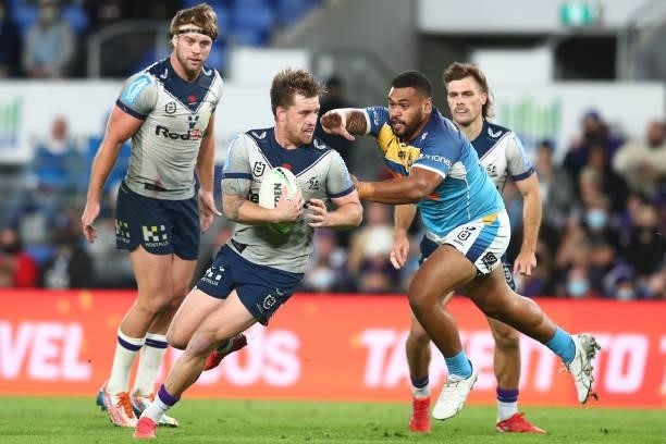 Cameron Munster of the Storm is tackled during the round 23 NRL match between the Gold Coast Titans and the Melbourne Storm at Cbus Super Stadium, on...