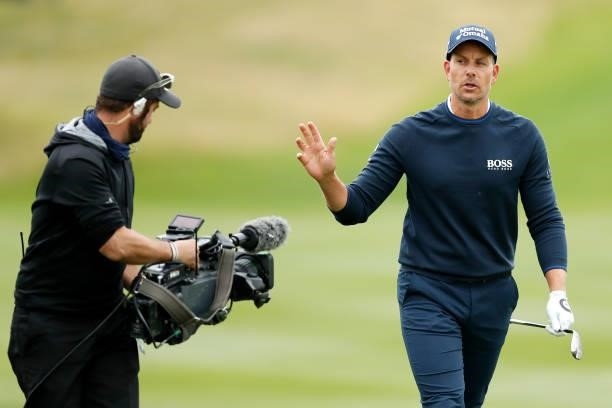 Henrik Stenson of Sweden reacts after playing a shot on the sixth hole as he is filmed by a TV camera operator during Day One of The D+D Real Czech...