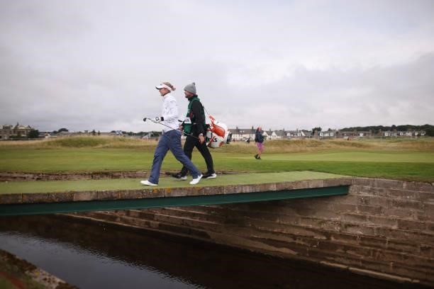 Nelly Korda of The United States and her caddie walk across a bridge over the Barry Burn during Day One of the AIG Women's Open at Carnoustie Golf...