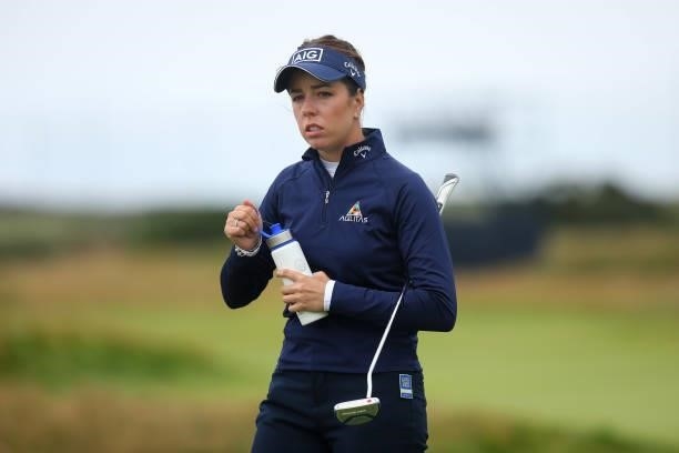 Georgia Hall of England looks on holding an official AIG Women's Open water bottle during Day One of the AIG Women's Open at Carnoustie Golf Links on...