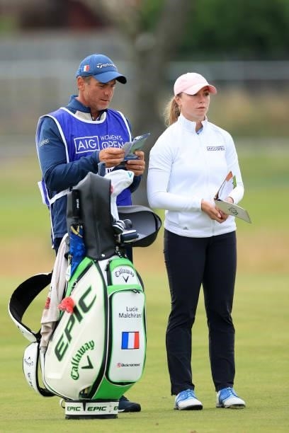 Lucie Malchirand of France looks on with her caddie as she prepares to play her second shot on the tenth hole during Day One of the AIG Women's Open...