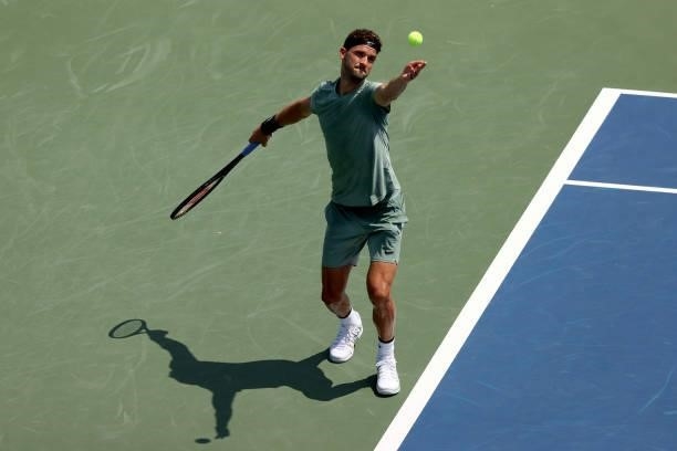 Grigor Dimitrov of Bulgaria serves to Daniil Medvedev of Russia during the Western & Southern Open at Lindner Family Tennis Center on August 19, 2021...