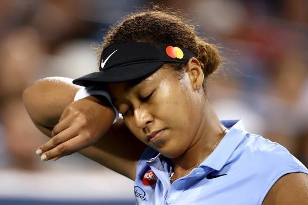Naomi Osaka of Japan wipes her face while playing Jill Teichmann of Switzerland during the Western & Southern Open at Lindner Family Tennis Center on...