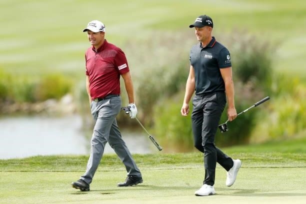 Padraig Harrington of Ireland speaks with Henrik Stenson of Sweden on the ninth hole during Day Two of The D+D Real Czech Masters at Albatross Golf...
