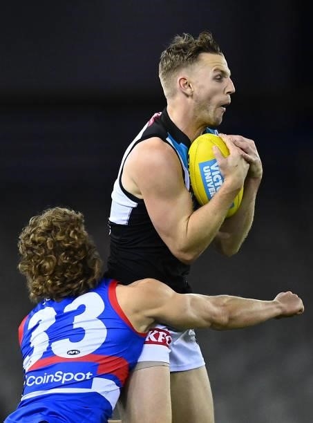 Trent McKenzie of the Power is tackled by Aaron Naughton of the Bulldogs during the round 23 AFL match between Western Bulldogs and Port Adelaide...