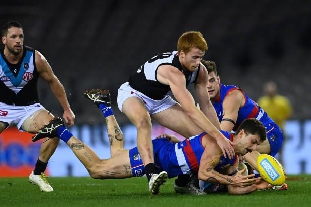 Tom Liberatore of the Bulldogs is tackled by Willem Drew of the Power during the round 23 AFL match between Western Bulldogs and Port Adelaide Power...