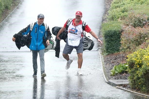 Caddies are seen returning to the clubhouse following a suspension in play due to heavy rain during Day Two of The D+D Real Czech Masters at...
