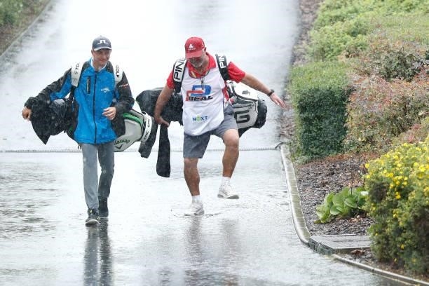Caddies are seen returning to the clubhouse following a suspension in play due to heavy rain during Day Two of The D+D Real Czech Masters at...