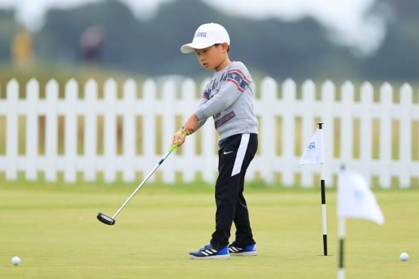 Young golf fan putts on the practice putting green in the Spectator Village during Day Two of the AIG Women's Open at Carnoustie Golf Links on August...