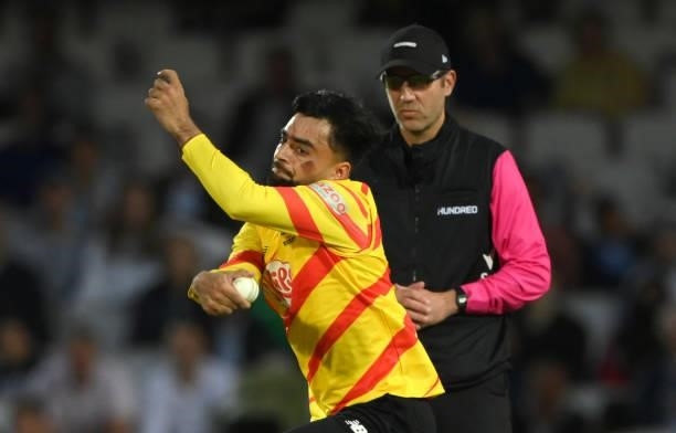 Rockets bowler Rashid Khan in bowling action with the colours of the Afghanistan flag painted on his face during the Eliminator match of The Hundred...