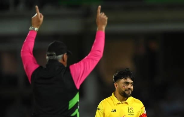 Rockets bowler Rashid Khan with the colours of the Afghanistan flag painted on his face reacts as Umpire David Millns signals a six off his bowling...