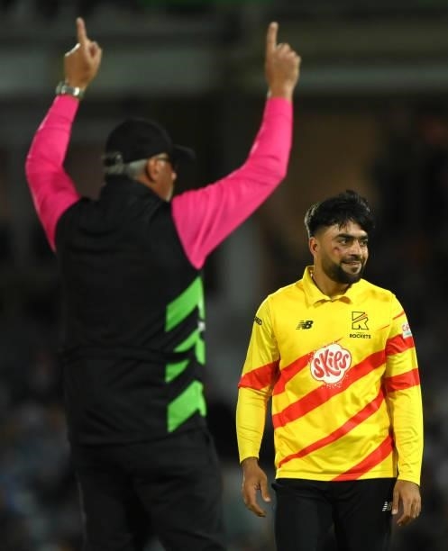 Rockets bowler Rashid Khan with the colours of the Afghanistan flag painted on his face reacts as Umpire David Millns signals a six off his bowling...