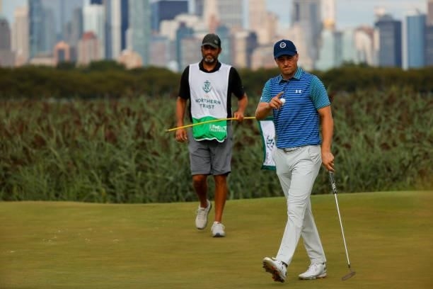 Jordan Spieth of the United States waves after putting on the 14th hole as caddie Michael Greller looks on during the second round of THE NORTHERN...