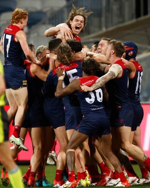 The Demons celebrate a goal to Max Gawn of the Demons after the siren to win the round 23 AFL match between Geelong Cats and Melbourne Demons at...