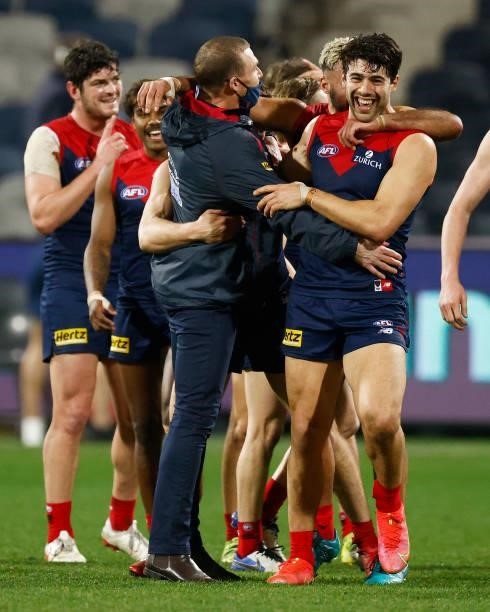 Demons head coach Simon Goodwin celebrates with Christian Petracca of the Demons and players after winning the round 23 AFL match between Geelong...