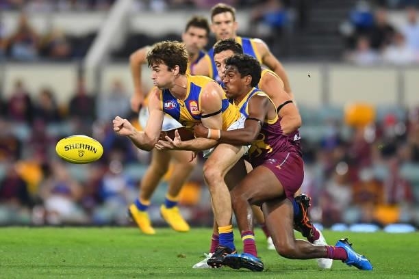 Jamie Cripps of the Eagles handballs under pressure from Keidean Coleman of the Lions during the round 23 AFL match between the Brisbane Lions and...