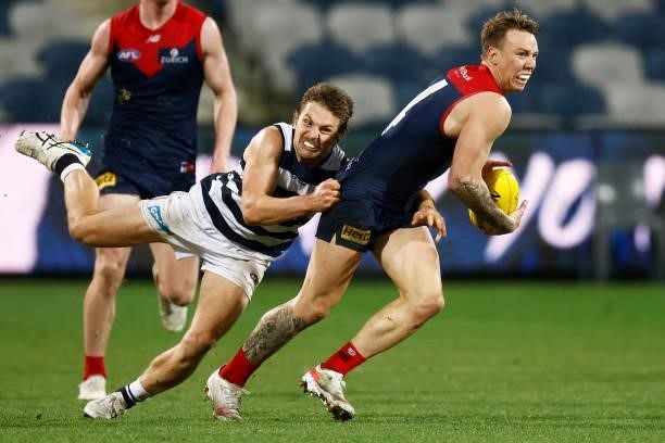 James Harmes of the Demons is tackled by Tom Atkins of the Cats during the round 23 AFL match between Geelong Cats and Melbourne Demons at GMHBA...