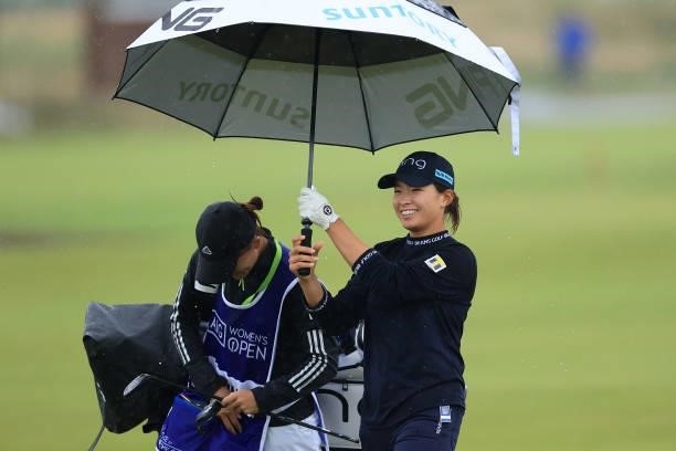 Hinako Shibuno of Japan holds an umbrella on the eighteenth hole during Day Three of the AIG Women's Open at Carnoustie Golf Links on August 21, 2021...