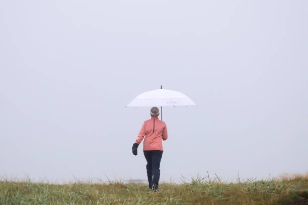 Nanna Koerstz Madsen of Denmark holds an umbrella as she walks along the course during Day Three of the AIG Women's Open at Carnoustie Golf Links on...