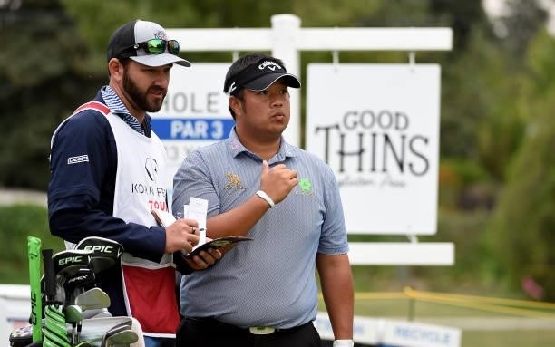 Kiradech Aphibarnrat of Thailand speaks with his caddie before he hits his tee shot on the eighth hole during the round three of the Albertsons Boise...